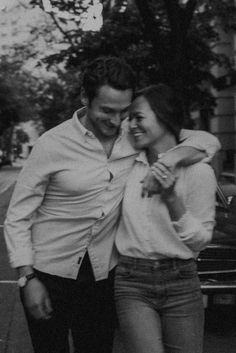 black and white photograph of man and woman walking down the street with their arms around each other