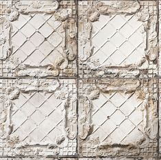 an old metal wall with decorative designs on it