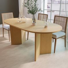 a wooden table with chairs around it in front of a large window and white curtains