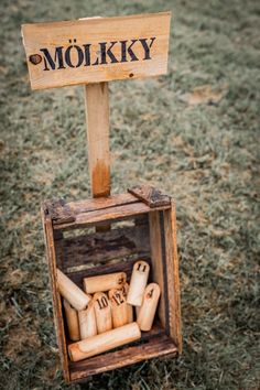 an old wooden box filled with lots of wine corks next to a sign that says molkky