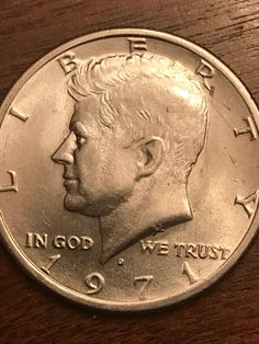 a close up of a coin on a wooden surface with the words in god we trust