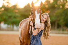 a beautiful young woman standing next to a brown and white horse