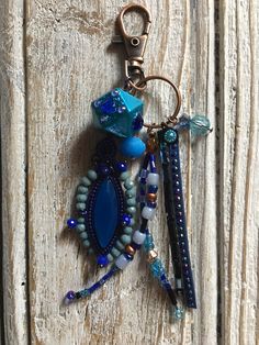 a keychain with beads and charms hanging from it's side on a wooden surface