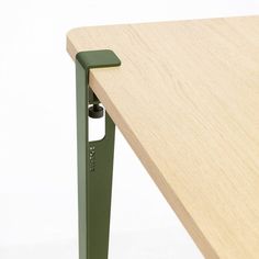 a wooden table with a green handle on it