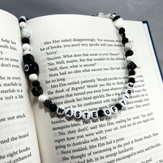 an open book with black and white beads on it