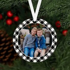 a christmas ornament hanging from a tree with a photo in the center on it