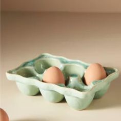 an egg tray with three eggs in it