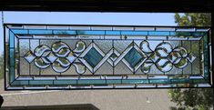 a stained glass window hanging from the side of a house