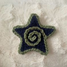 a crocheted star ornament with a spiral design on it sitting on a white surface