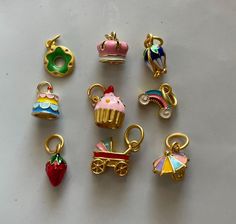 there are many different charms on the table, including one with a cupcake and other with an umbrella