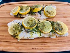 fish with herbs and lemons on a cutting board