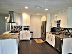 a kitchen with white cabinets and stainless steel appliances