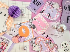 halloween themed paper decorations are laid out on a table with purple and orange accents,