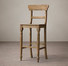 a wooden chair sitting on top of a hard wood floor next to a white wall