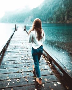 a woman walking on a dock in the rain