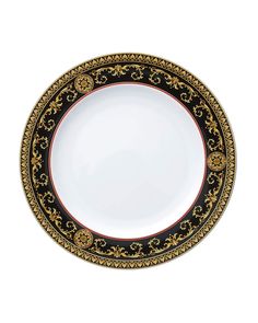 an ornate black and gold plate with red trimmings on the rim, set against a white background