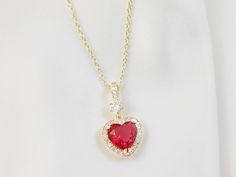 "This red heart necklace is made a 10mm ruby red cubic zirconia crystal heart, which is surrounded by sparkly clear cubic zirconia stones and dangles below a cubic zirconia bail on a lovely gold cable chain with a teardrop lobster clasp. This adjustable necklace can be worn from 16 to 19 inches and makes a lovely jewelry gift for her. Thank you for looking. NOTE: Gemsicles' gold-filled, rose/gold-plated, antiqued, matte, silver and rhodium jewelry is cadmium-free, lead-free and nickel-free. Also Cubic Zirconia Heart Necklace With Gemstone For Valentine's Day, Heart Necklace With Cubic Zirconia For Valentine's Day, Valentine's Day Heart Necklace With Cubic Zirconia Gemstone, Red Heart-shaped Cubic Zirconia Jewelry, Red Cubic Zirconia Heart Pendant Jewelry, Red Heart-cut Cubic Zirconia Necklace, Red Heart Cut Cubic Zirconia Necklace, Ruby Heart Pendant Jewelry For Valentine's Day, Ruby Heart Pendant For Valentine's Day