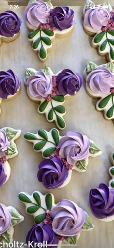 decorated cookies in the shape of roses on a baking sheet