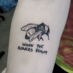 a black and white photo of a bee with the words, when the flowers bloom