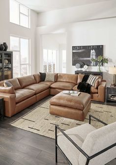 a living room filled with furniture and large windows