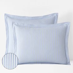 two blue and white striped pillow cases on top of each other, one has a button at the bottom