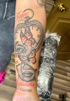 a person with a tattoo on their arm that has a clock and a butterfly in it