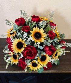 a bouquet of sunflowers and roses on a table