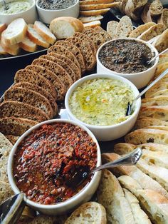 breads and dips are arranged on a table