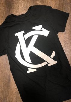 Rally Kansas City Monogram Black Short Sleeve Fashion T Shirt Short Sleeve Monogram Print T-shirt For Streetwear, Streetwear Monogram Print Short Sleeve T-shirt, Summer Streetwear T-shirt With Monogram Print, Monogram Print Short Sleeve T-shirt For Streetwear, Summer Monogram Print T-shirt With Short Sleeves, Monogram Print Graphic Tee For Streetwear, Black Cotton T-shirt With Letter Print, Cotton T-shirt With Black Letter Print, Crew Neck T-shirt With Monogram Print For Streetwear