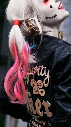 a woman with pink hair and makeup wearing a black jacket