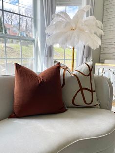 a couch with two pillows on it and a large white flower