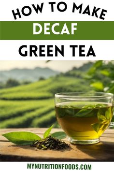 a glass cup filled with green tea sitting on top of a wooden table next to some leaves