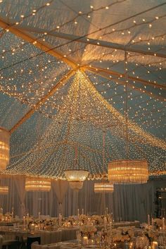 the inside of a tent with lights and chandeliers