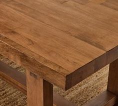 a wooden table sitting on top of a rug