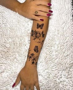 a woman's arm with flowers and butterflies on it