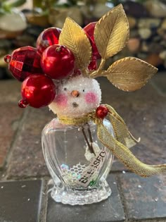 a glass vase filled with red and gold ornaments