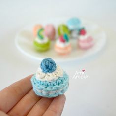 small crocheted cupcake on a plate with miniature cookies in the background