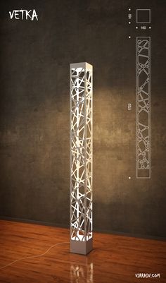 a tall white lamp sitting on top of a wooden floor next to a black wall