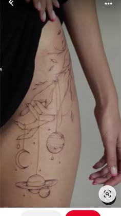 a woman's thigh with tattoos on it and planets in the sky behind her