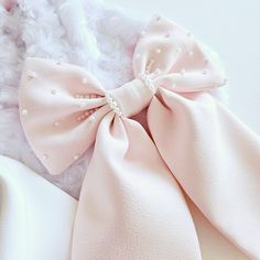 Bespoke large bow in pink satin .  Hand beaded pearl bow tails for a soft sparkle and a touch of elegance. Size: 9 inches. Materials: Satin , pearl beads Finish: Alligator clip. Pink Bow Tie Hair Accessories For Party, Elegant Pink Hair Accessories With Bow, Pink Decorative Bow Hair Accessories For Wedding, Pink Hair Accessories With Decorative Bow For Wedding, Pink Wedding Hair Accessories With Decorative Bow, Pink Satin Wedding Bow, Pink Bow Hair Accessories For Wedding, Elegant Pink Ribbon Hair Accessories, Pink Satin Bow Hair Accessories For Wedding