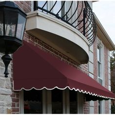 an awning on the side of a brick building with a lamp post in front of it