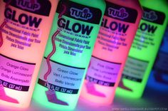 glow bottles with different colors on them sitting next to each other in front of a black light background