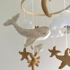 a baby mobile with sea animals hanging from it's sides and clouds in the background