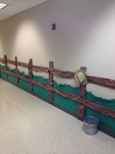 an empty room with a wooden fence and buckets on the floor next to it