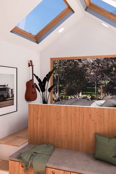 a living room with a couch and a guitar on the window sill next to it