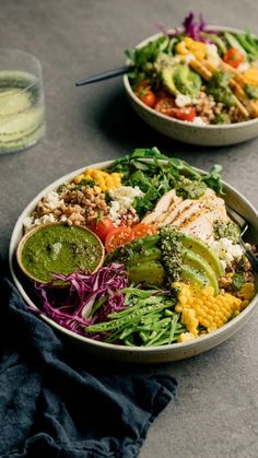 two bowls filled with different types of salads on top of a gray countertop