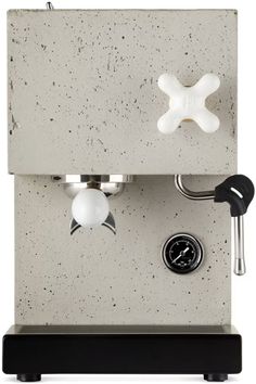 a coffee machine that is made out of concrete and has a clock on the side