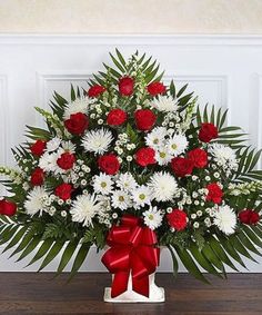 a large red and white arrangement in a basket