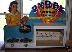 there is a toy oven that has a woman holding a tray in front of it