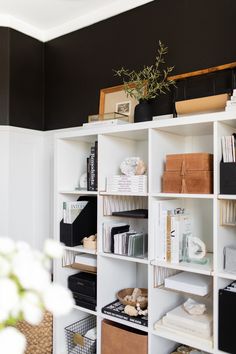 a white book shelf filled with lots of books and other items on top of it